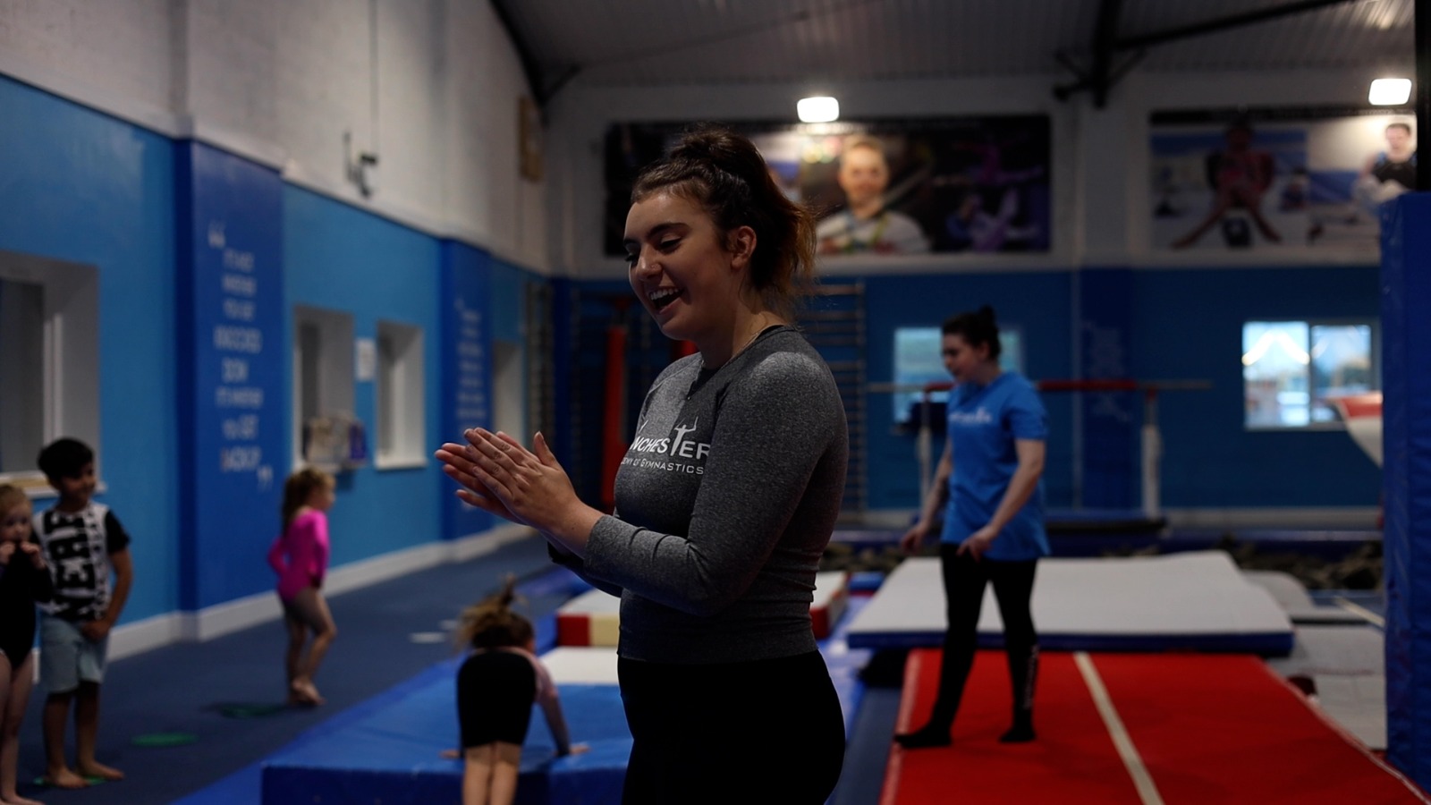 Coach supporting a young gymnast at Manchester Academy of Gymnastics
